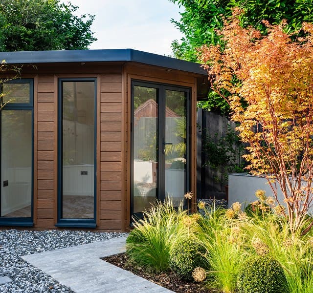 Glazed garden room approached through planting